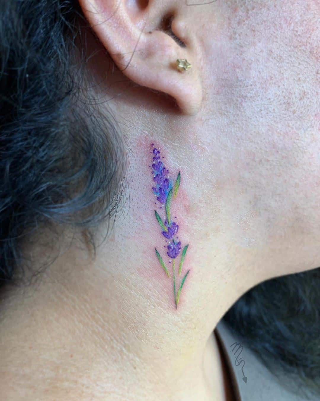A lavender tattoo behind the ear