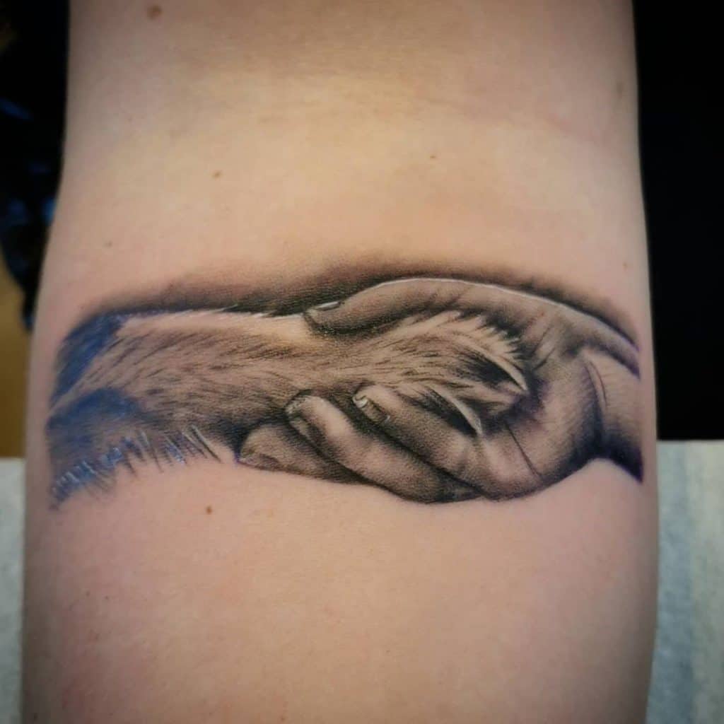 Woman Hand And Dog Paw Tattoo
