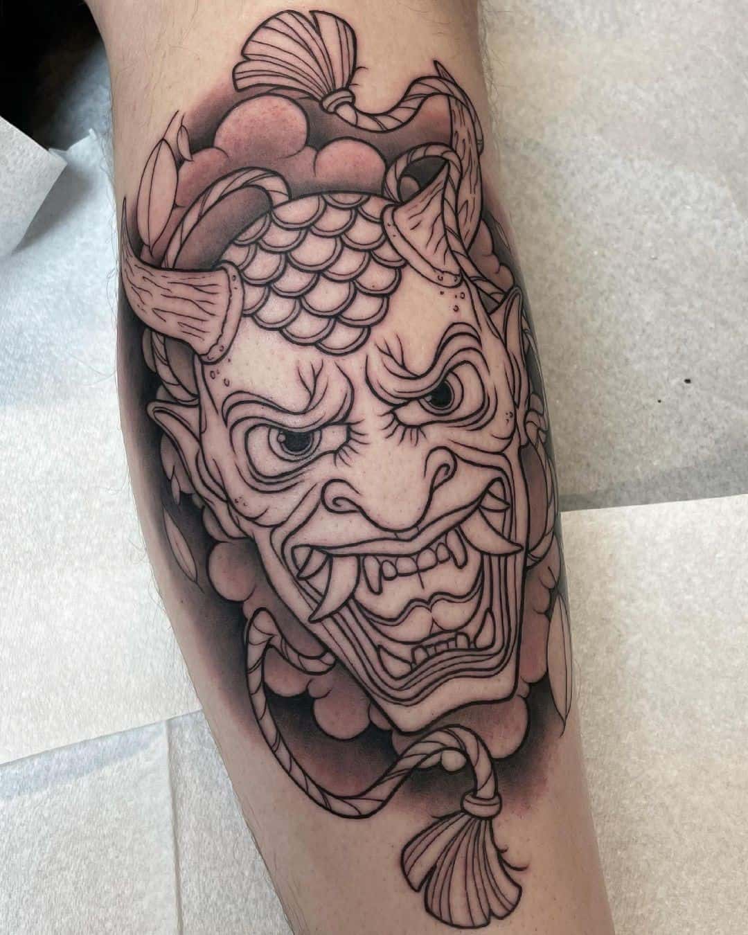 Detailed Oni Mask Tattoo Over Leg