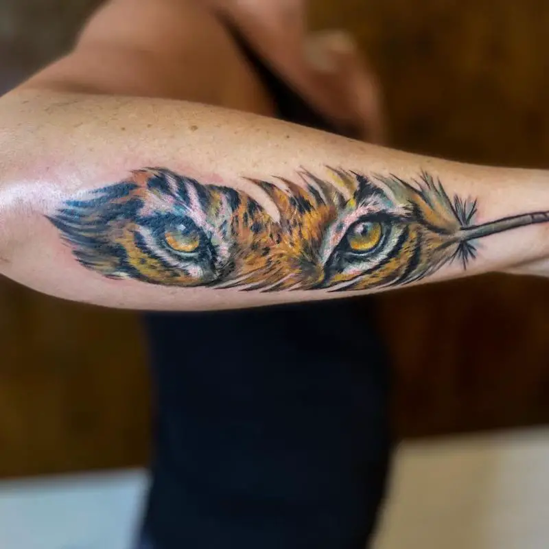 Tiger Eyes On A Feather Tattoo Design